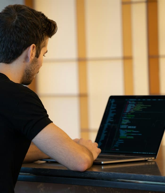 A developer shipping code from a laptop in a bright workspace