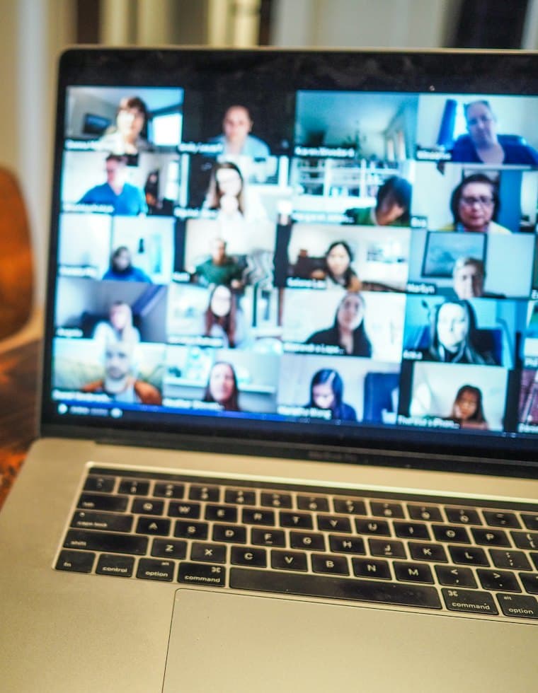 A laptop showing a video call with a full grid of participants